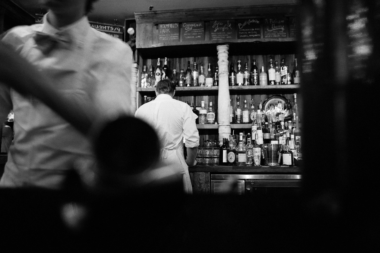 Bartenders working behind a bar counter at night