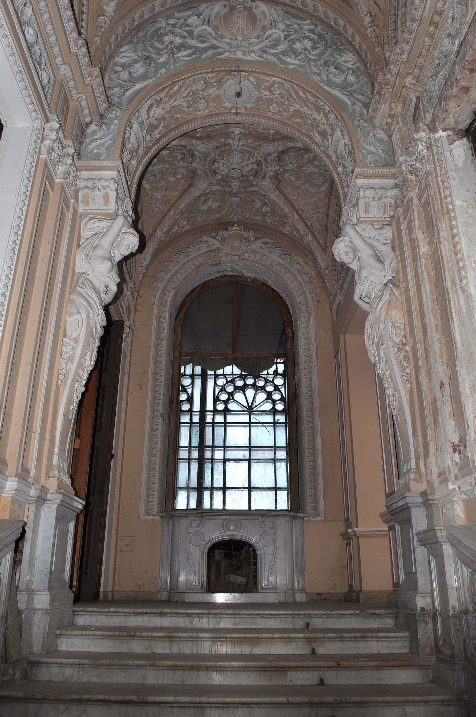 The grand staircase with caryatids and a marble fireplace