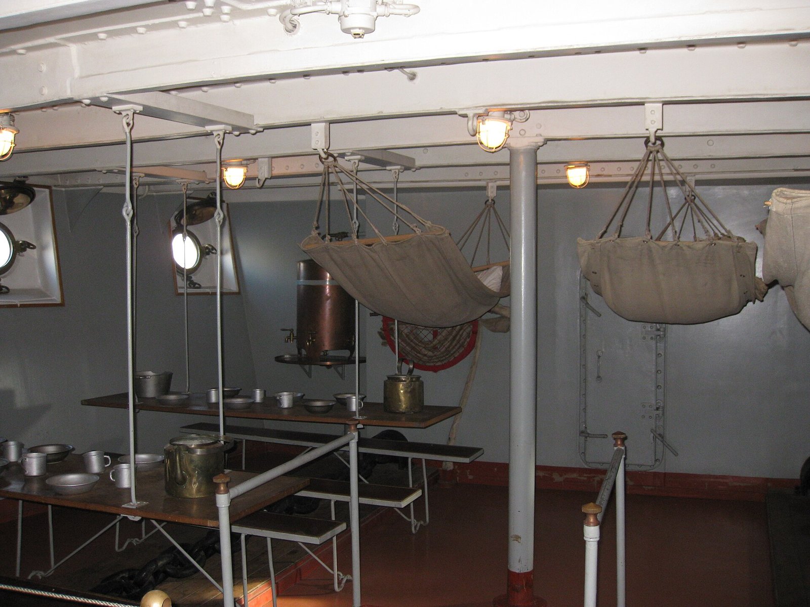 The sailors' mess deck on Aurora: hanging hammocks and tables laid with tableware