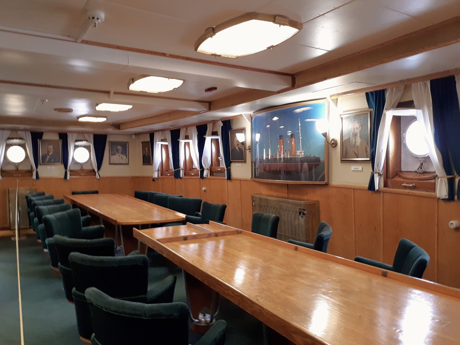 A room with long tables, portraits and a model of the icebreaker on Krasin