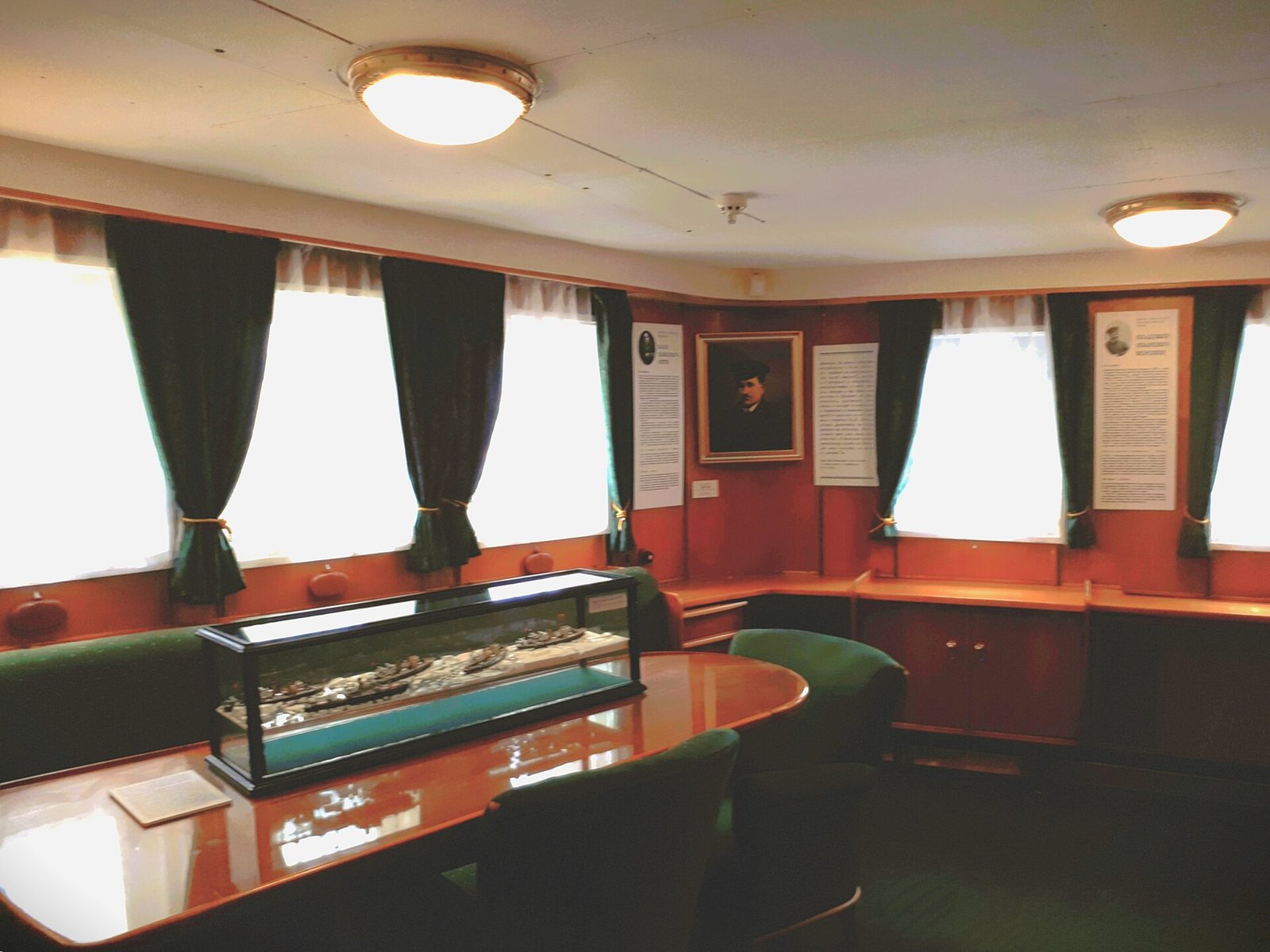 A museum room on Krasin: portraits and a display case with a model of ships in ice