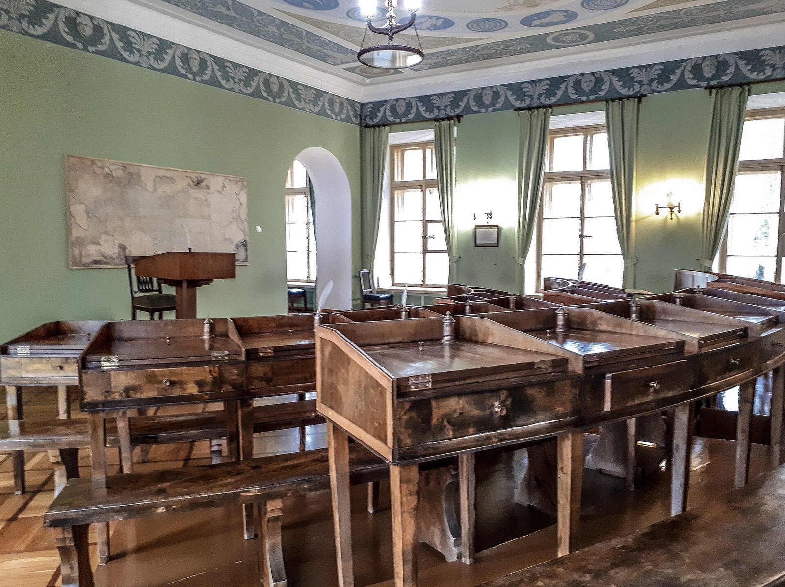 A Lyceum classroom with desks and a lectern