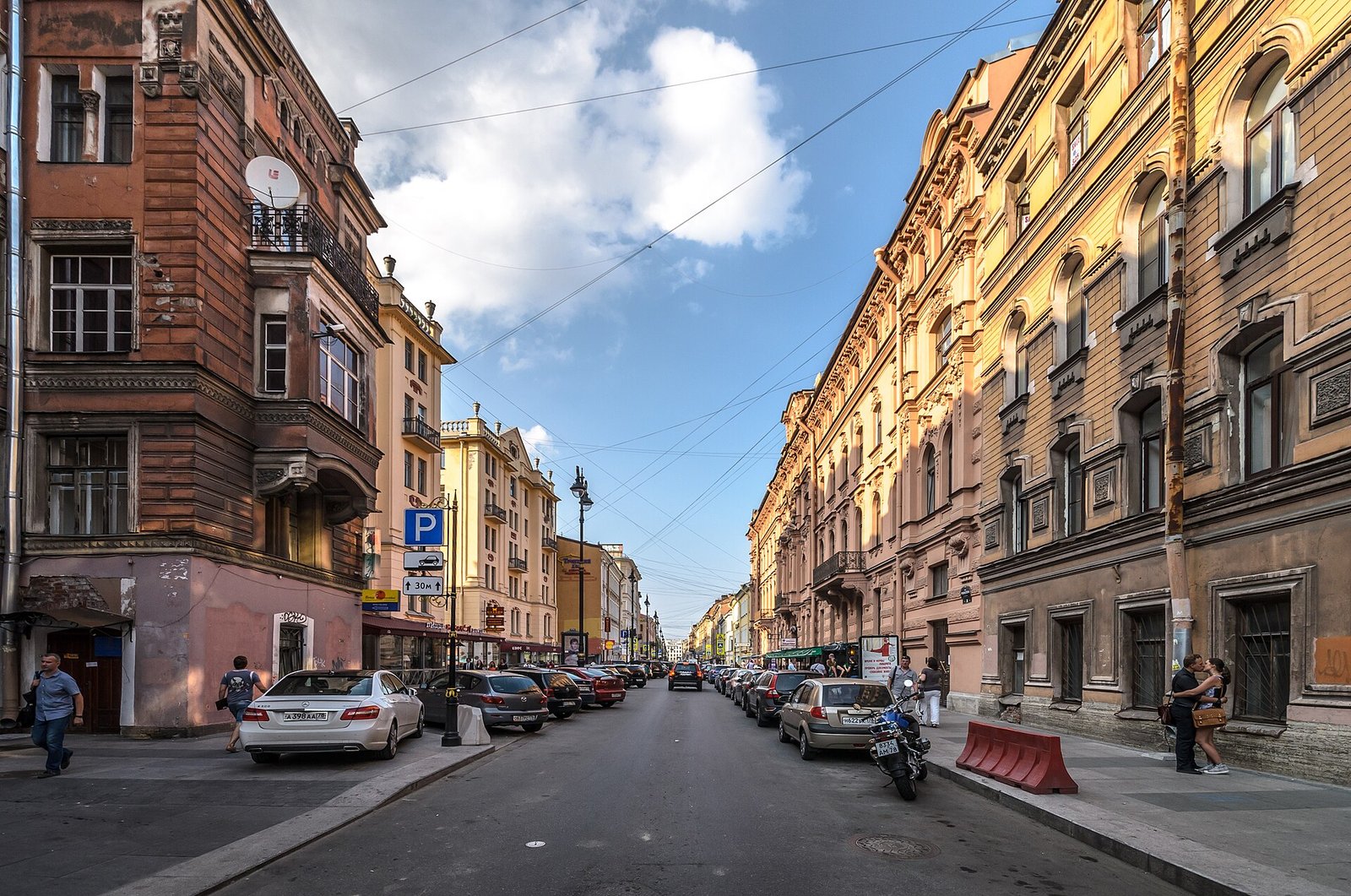 Rubinstein Street by day: apartment buildings and venue signs along the pavements
